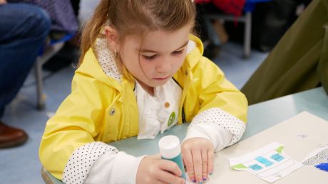 Young girl using a glue stick for an art project